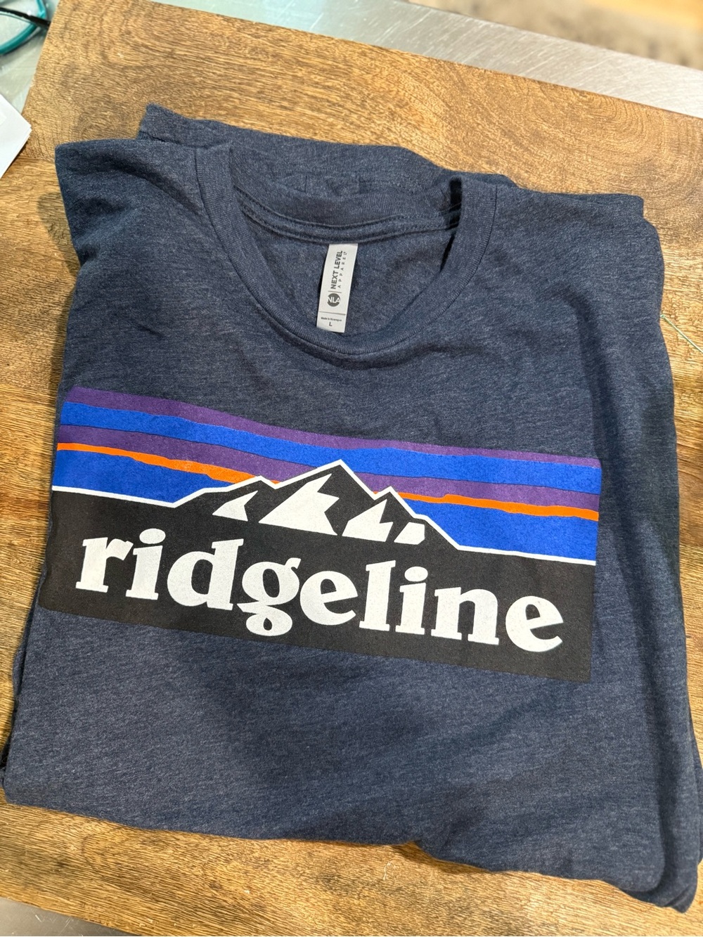 Next Level Apparel Navy Ridgeline Mountain Logo Tee with Blue and Purple Stripes